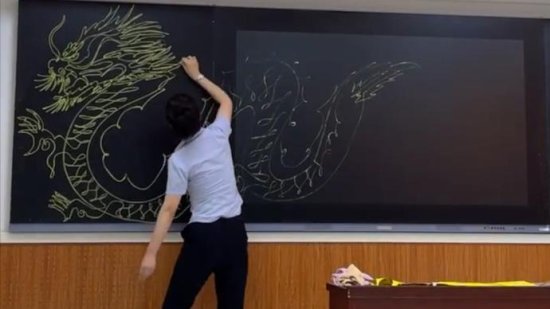 美术老师用粉笔在黑板上<em>一笔画</em>龙